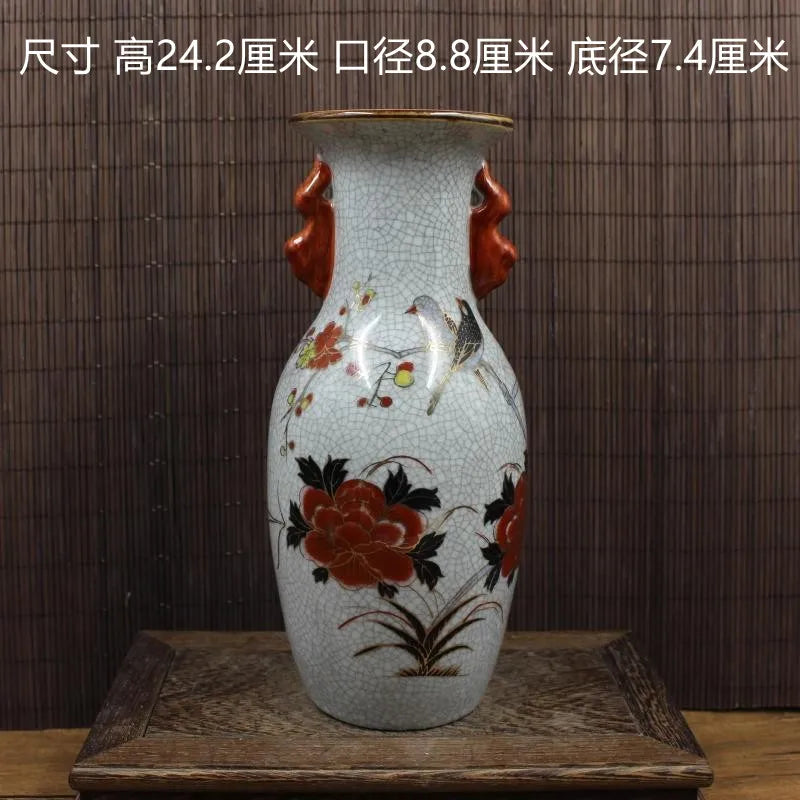 Vase en porcelaine vintage décoré de motifs floraux rouges sur un fond craquelé blanc.
