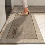 Gros plan sur un tapis motif grillage beige et marron, sur lequel se trouve un pied chaussé d'une paire de mocassins.