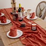 serviette table carrée orange franges moderne élégante fourchettes cuillères assiettesbranches séchées guirlande bougie parfumée