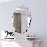 Décor élégant d'une chambre avec un miroir, une statue de cheval et un plateau décoratif sur une commode blanche.