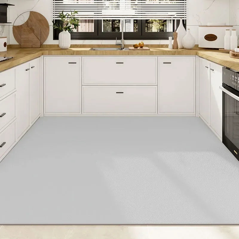 Cuisine minimaliste avec des meubles blancs, un comptoir en bois clair et des accents de plantes vertes, reflétant un design épuré et fonctionnel.