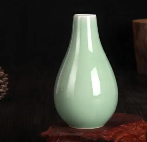 Un vase en porcelaine de couleur vert clair élégant et raffiné, posé sur fond sombre.