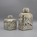 Pots décoratifs en céramique blanche et dorée avec motifs géométriques complexes.