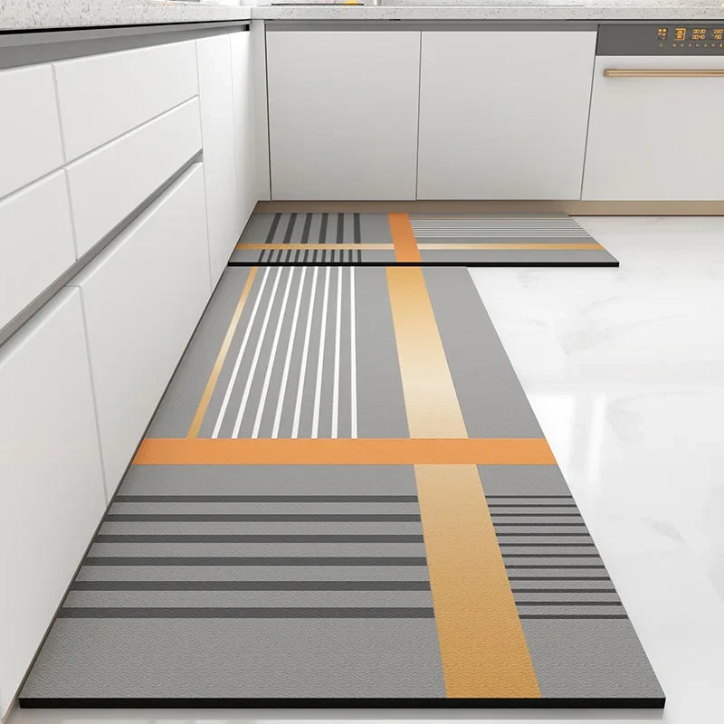 Motif géométrique abstrait avec des lignes horizontales et diagonales de différentes nuances de gris et de couleurs orange sur un sol carrelé dans une cuisine moderne.