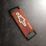 signalisation toilettes moderne symboles homme femme texte TOILET bois brun clair blanc tringle noire