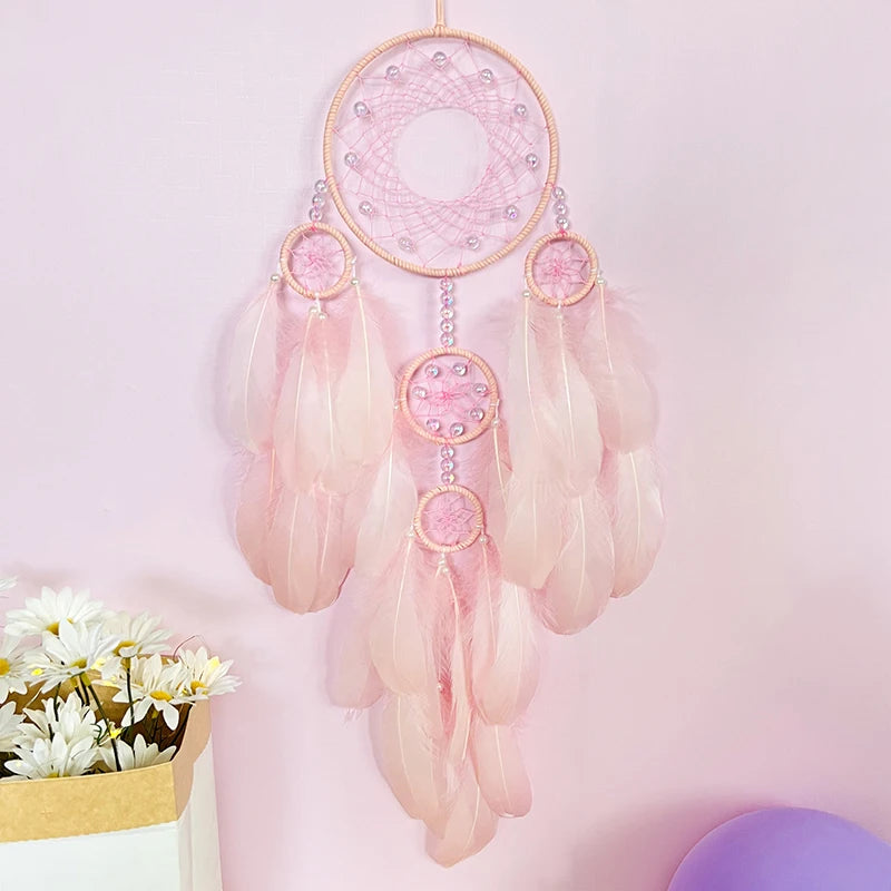 Le rêve capteur rose pastel avec ses cercles tressés et ses plumes délicates crée une atmosphère apaisante et sereine.