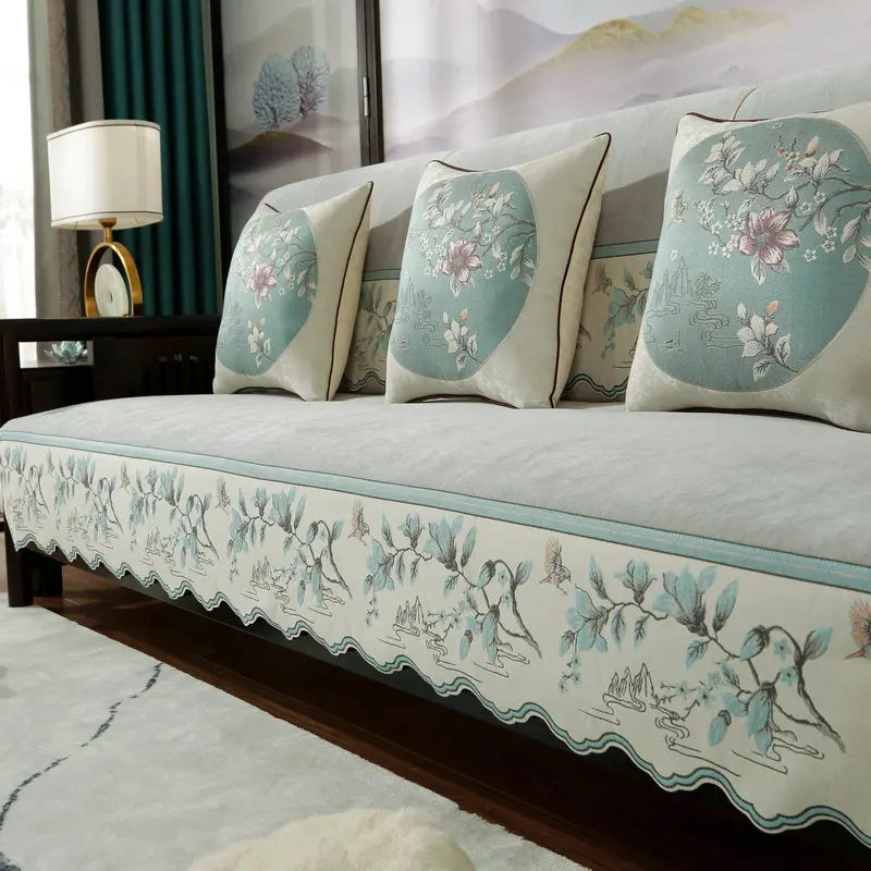 Un canapé confortable et élégant avec des coussins ornés de motifs floraux délicats dans des teintes douces de vert et de rose.