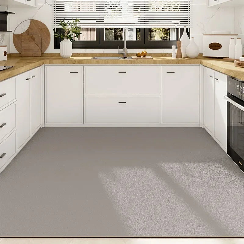 Une cuisine élégante et moderne avec des armoires blanches, un comptoir en bois clair et un plancher gris.