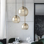 Lampe suspendue en verre verte suspendue au-dessus d'une table de cuisine