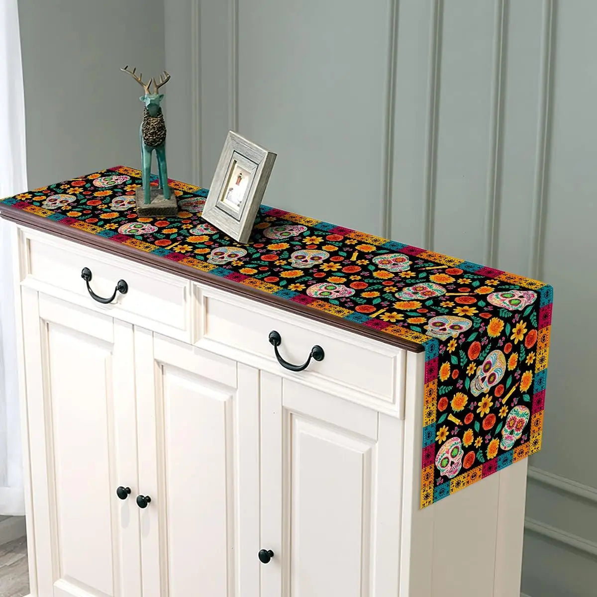Un meuble de buffet blanc avec des décorations colorées et des têtes de mort.