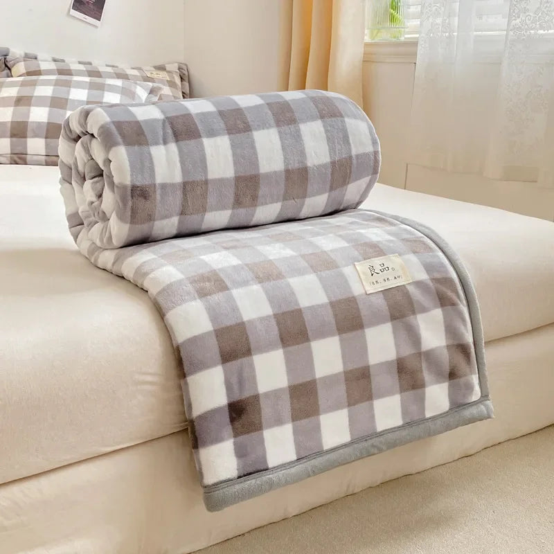 Couverture d'ameublement à motif carreaux blancs et gris posée sur un canapé beige dans un salon confortable.