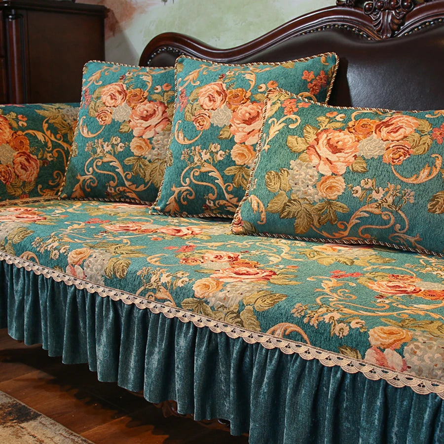 Un canapé antique aux motifs floraux élégants et colorés dans des tons de vert et de orange, avec des coussins assortis, créant une atmosphère chaleureuse et luxueuse.