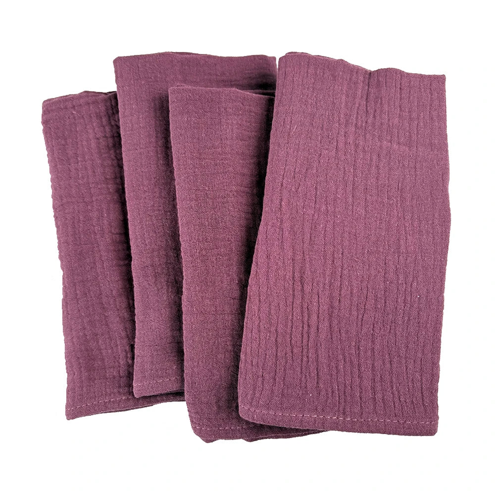 Un ensemble de serviettes de bain en tissu doux et texturé de couleur bordeaux.