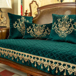 Des coussins de velours vert émeraude ornés de motifs dorés raffinés, avec une magnifique couverture matelassée au même motif, créent une atmosphère luxueuse et chaleureuse dans cette élégante pièce d'ameublement.