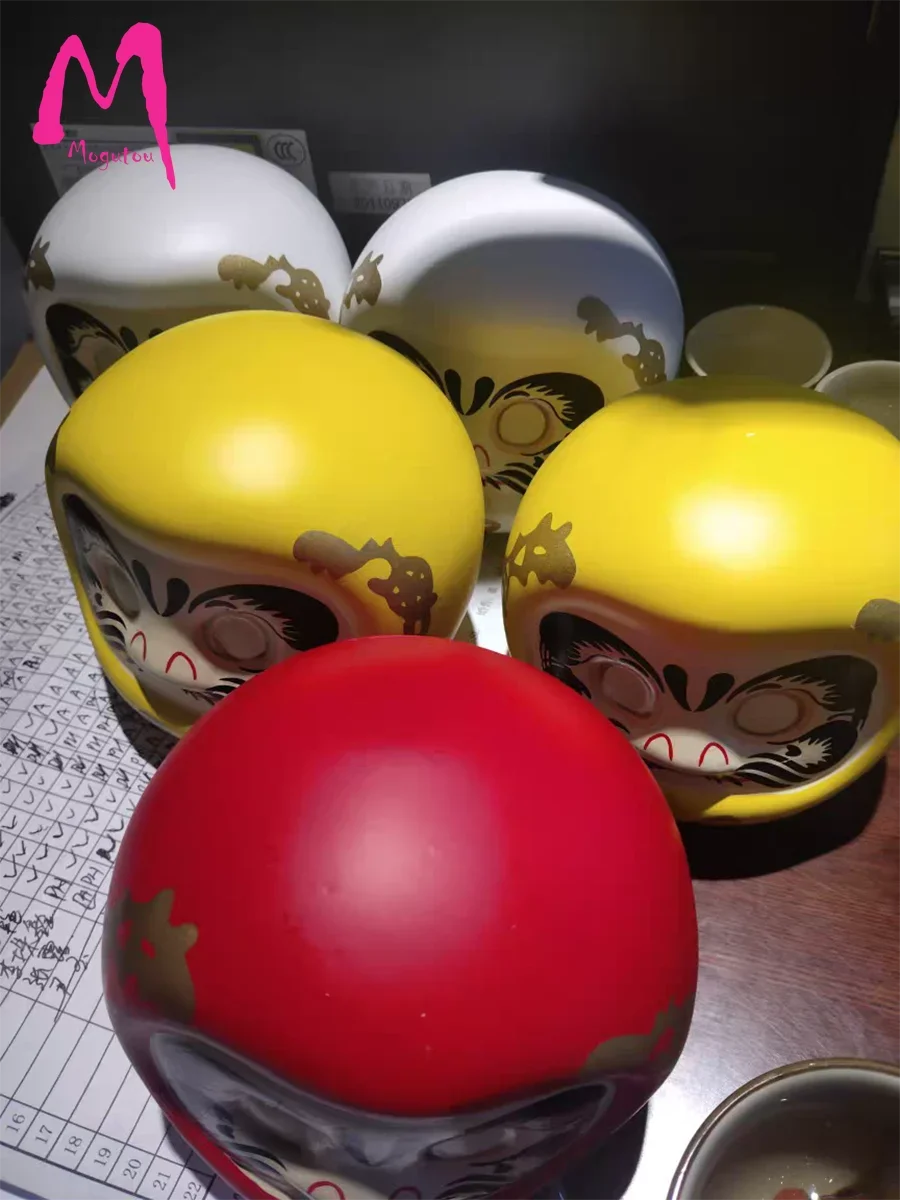 statuette japonaise daruma rouge blanche visage sourire yeux grands ouverts motifs dorés traditionnels décoration