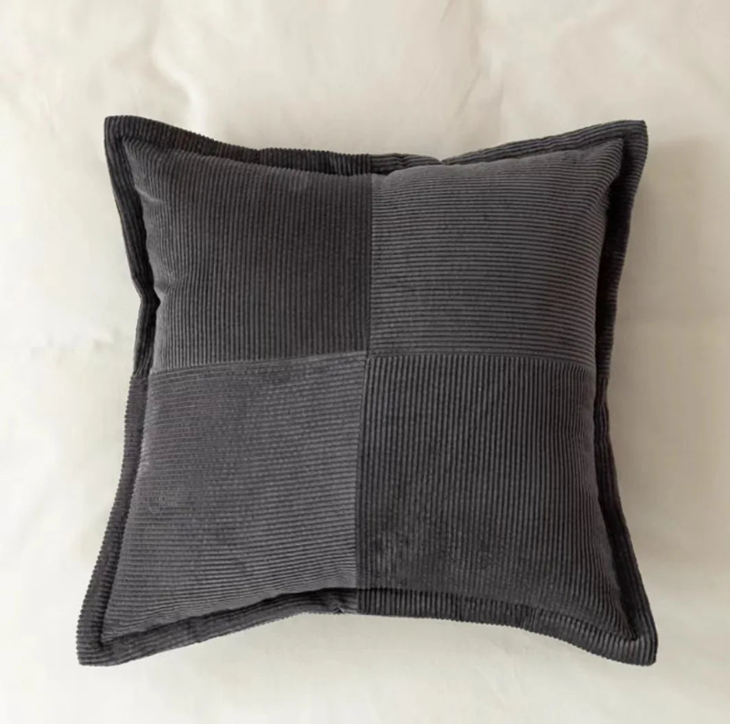 Coussin décoratif gris avec motif de rayures côtelées, élégant et moderne pour une décoration d'intérieur chic.
