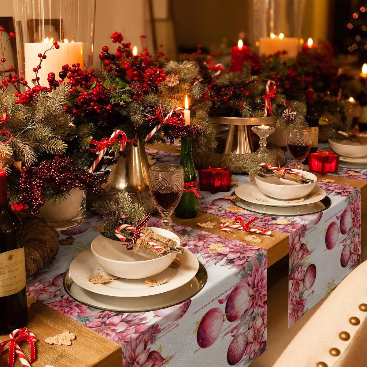 Une table festive joliment décorée pour les fêtes, avec des bougies, des baies rouges, des branches de sapin et des plats élégants.