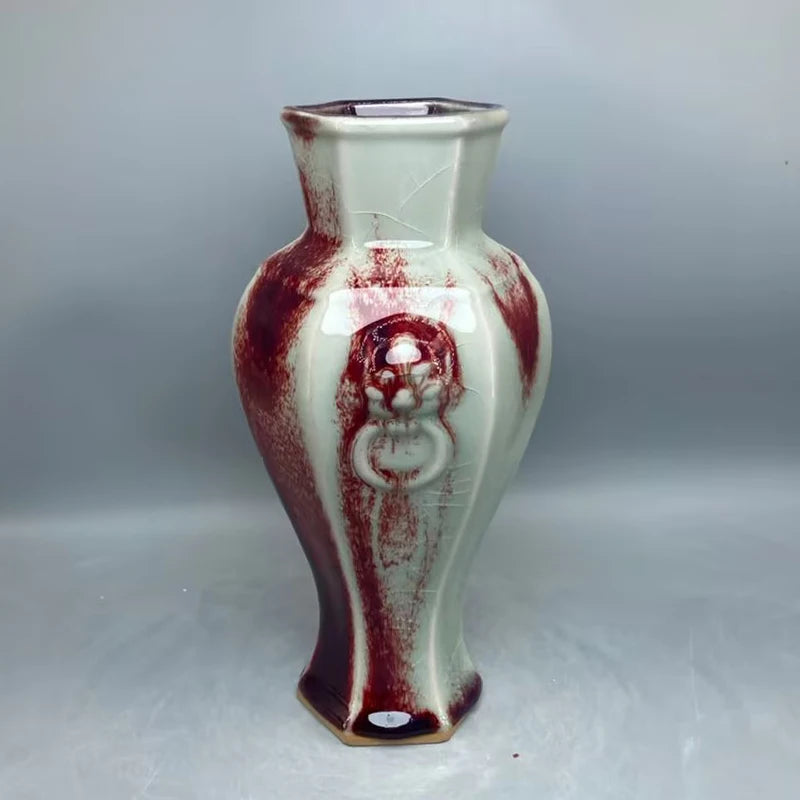 Vase en céramique émaillée aux motifs rouges et blancs, avec un design unique et artisanal.