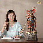 statue personnage masculin armure bâton socle rocheux motifs complexes couleurs or rouge bleuTextures variées