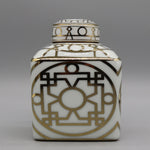 Élégante poterie décorative blanche et dorée avec un motif géométrique abstrait complexe.