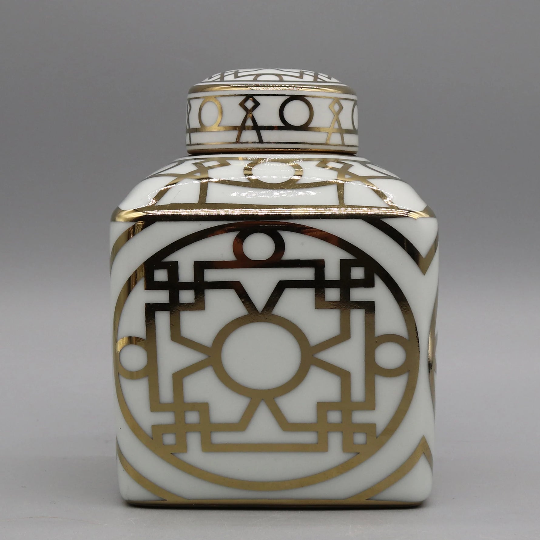 Élégante poterie décorative blanche et dorée avec un motif géométrique abstrait complexe.