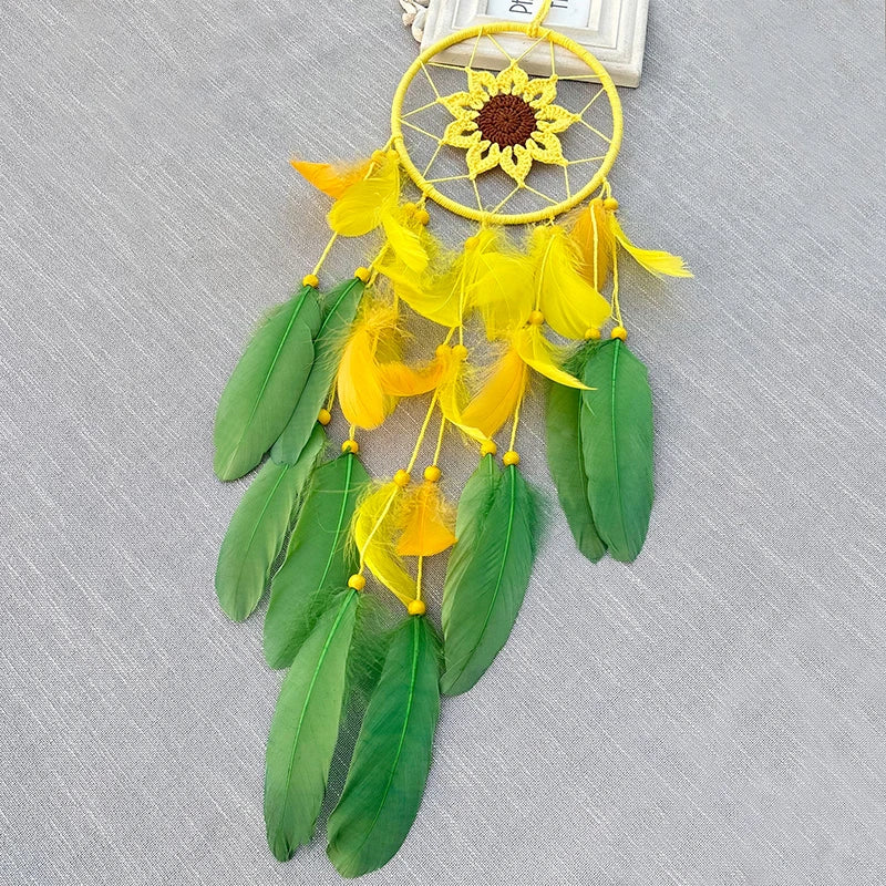 Un capteur de rêves en forme de soleil, aux couleurs jaune et vert, avec des plumes et une fleur centrale.