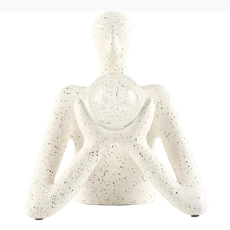 statue décorative personnage humain sphère transparente motifs internes neige cristaux blanc taches noires.texture granuleuse