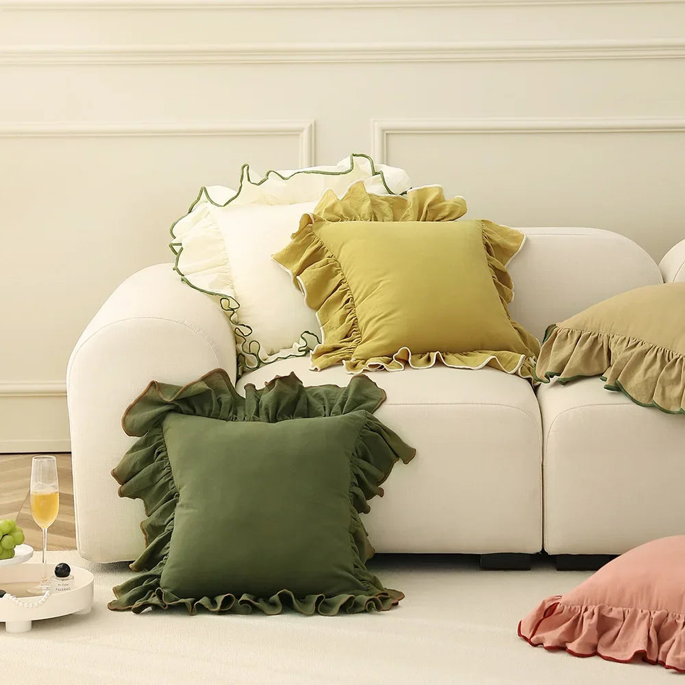 Un canapé blanc avec des coussins et des oreillers décoratifs de couleurs jaunes et vertes, créant une ambiance chaleureuse et accueillante dans cet intérieur élégant.