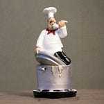 statue cuisinier cartoon uniforme blanc tablier noir chapeau cuillère dorée bouteille pot pomme terre