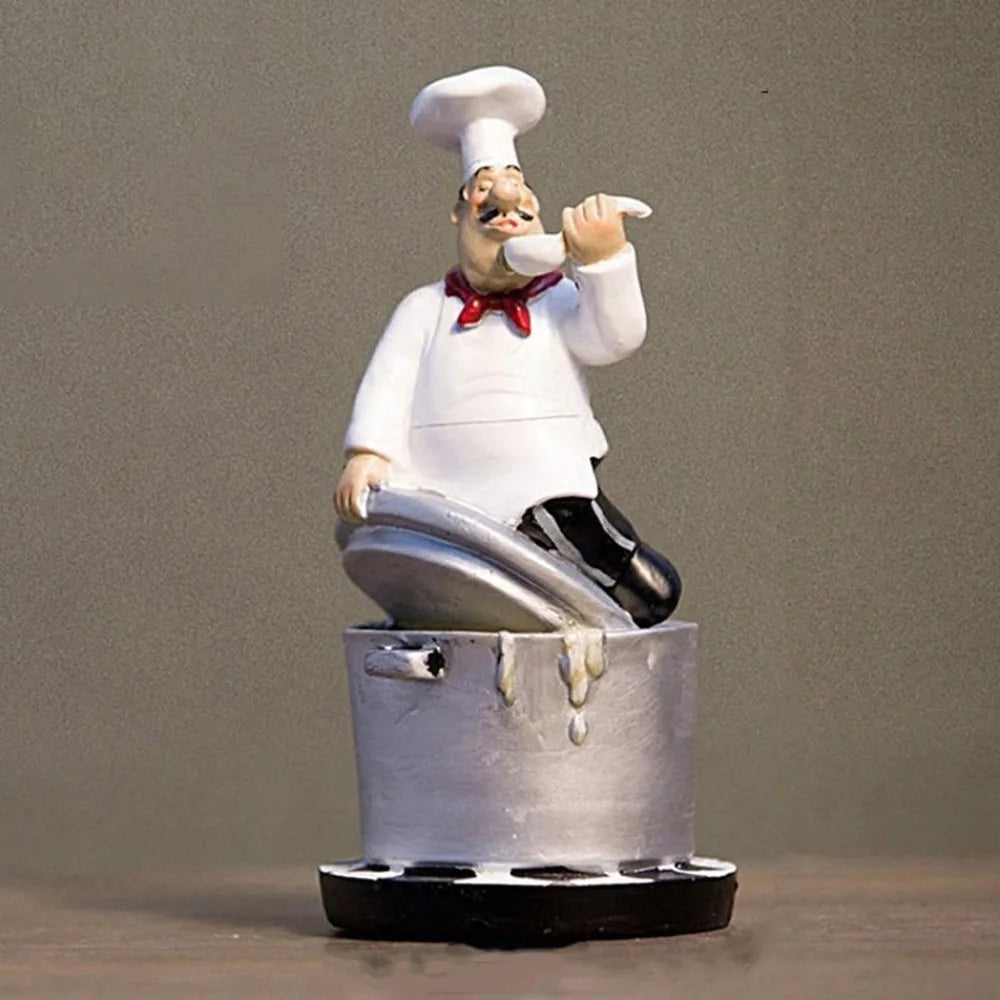 statue cuisinier cartoon uniforme blanc tablier noir chapeau cuillère dorée bouteille pot pomme terre