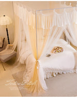 Une chambre à coucher à l'atmosphère douce et romantique, avec un lit à baldaquin orné de rideaux en voile blanche et un bouquet de fleurs posé sur le lit.