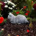 ornement zen statue chat gris allongé texture pierreuse jardin fleurs plantes
