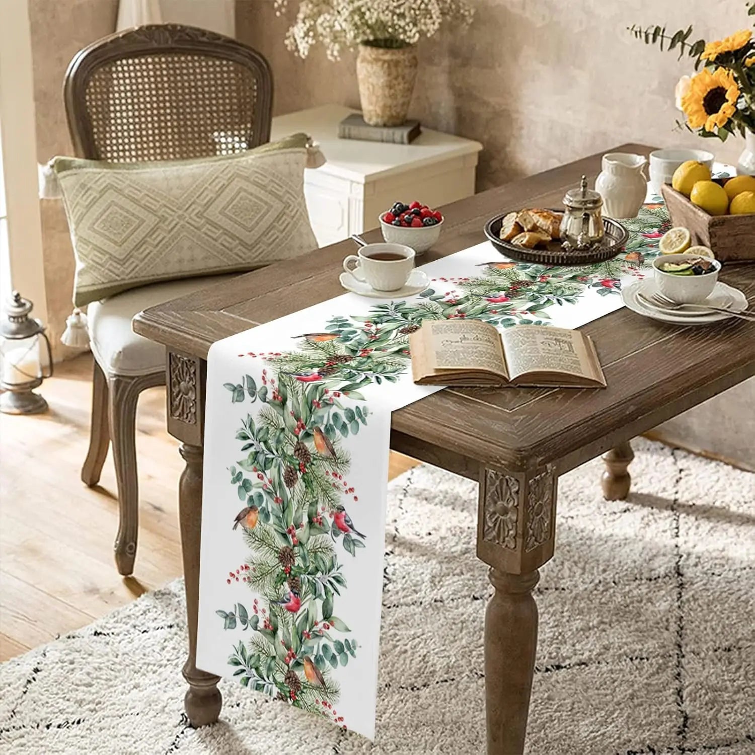 Une table de fête rustique joliment décorée avec un chemin de table fleuri, des fleurs, des fruits et un livre ouvert, créant une ambiance chaleureuse et accueillante.