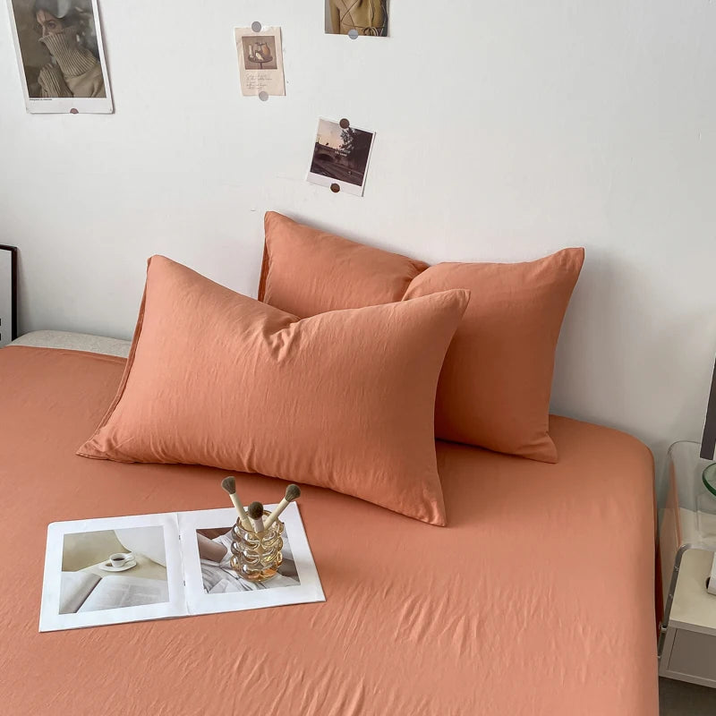Un gros plan sur un canapé confortable recouvert de coussins orangés, sur lequel se trouvent des photos d'inspiration accrochées au mur.