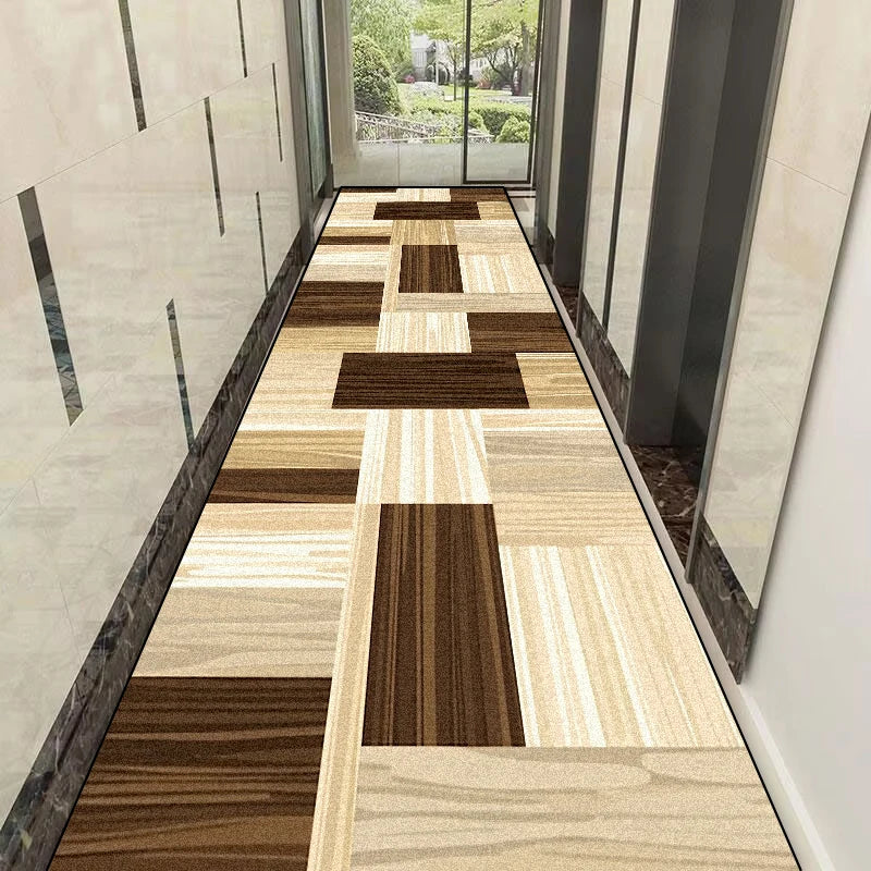 Un couloir moderne avec un motif géométrique de carreaux en différentes nuances de beige et de brun, créant un design élégant et harmonieux.