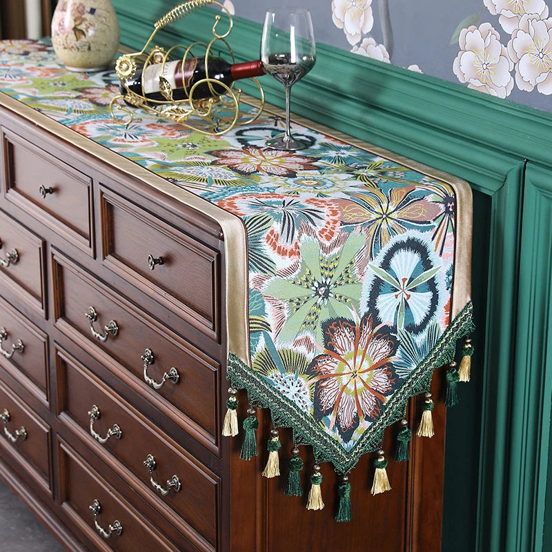 Élégant meuble avec un chemin de table décoratif aux motifs floraux colorés et accents dorés, créant une atmosphère chaleureuse et raffinée.