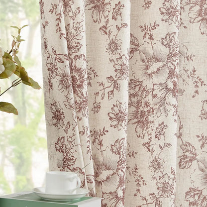 Voilage fleuri beige et bordeaux légèrement entrouvert, laissant passer la lumière naturelle, avec une tasse à café posée sur une table verte.