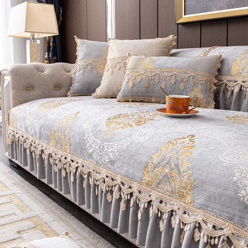 Une chambre à coucher élégante avec un lit capitonné recouvert d'une belle literie aux motifs dorés et beiges, agrémentée de coussins assortis et d'une tasse de boisson posée sur le bord du lit.