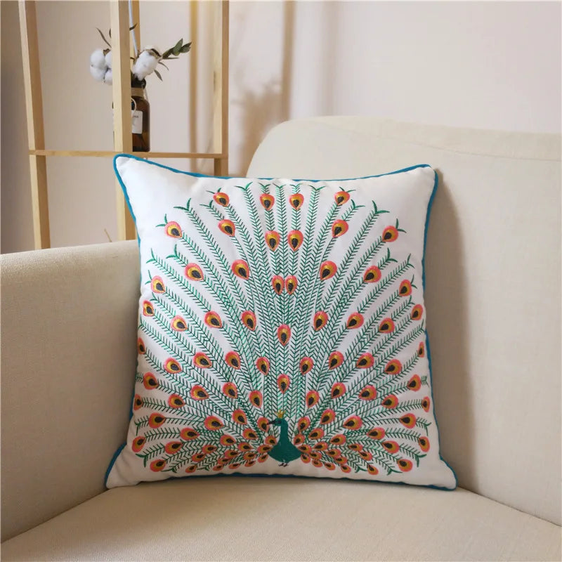 Un coussin avec un motif coloré de paon en plumes rouges et vertes sur un fond blanc, offrant une touche décorative apaisante à l'intérieur.