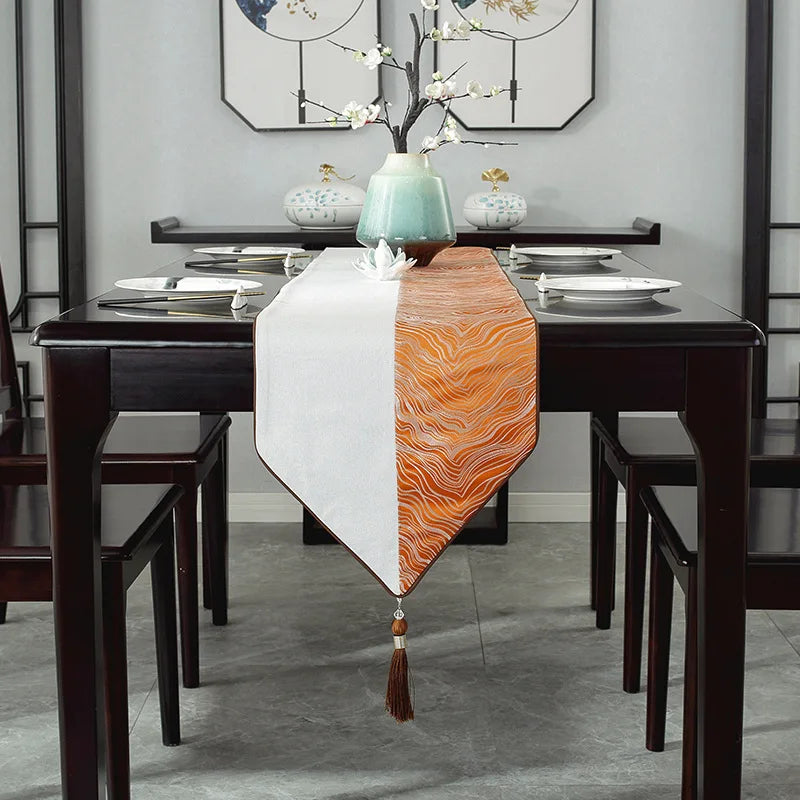 La table de salle à manger élégante est agrémentée d'un chemin de table bicolore et de décorations florales, créant une ambiance chaleureuse et zen.
