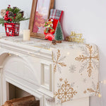 Une décoration de Noël avec des éléments festifs tels qu'un cadre, un arbre décoratif et des détails dorés sur une surface blanche.