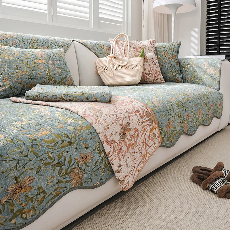 Ce canapé fleuri aux tons verts et roses, avec des motifs de fleurs et de feuillages, crée une ambiance chaleureuse et accueillante dans cette pièce ensoleillée.