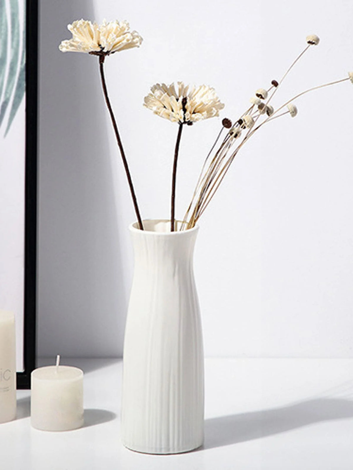 vase moderne minimaliste blanc strié rose blanc jaune séché roses bougies tableau chaise tissu