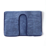 Un tapis de bain bleu marine en tissu éponge doux et moelleux.