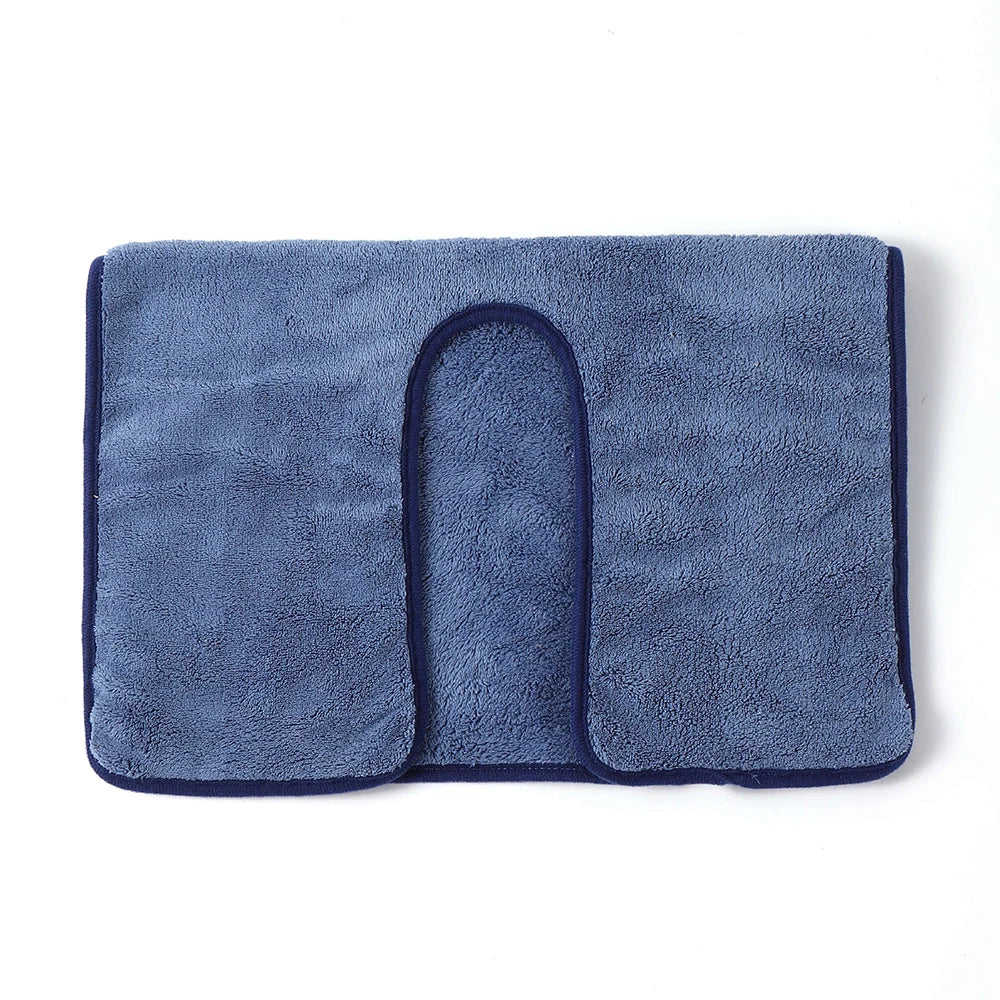 Un tapis de bain bleu marine en tissu éponge doux et moelleux.