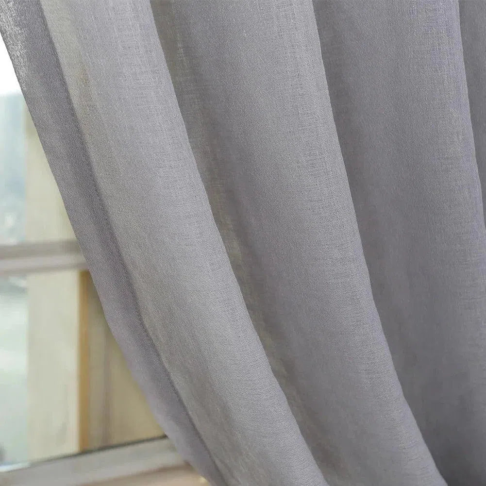 Rideau gris élégant pour salon moderne, offrant une touche de sophistication à votre décoration intérieure. Ce rideau permet de filtrer doucement la lumière, créant ainsi une ambiance apaisante et agréable. Idéal pour habiller vos fenêtres tout en préservant votre intimité. Accessoire décoratif chic pour ajouter une note contemporaine à votre maison.