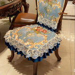 Le fauteuil décoré d'un élégant motif floral sur fond bleu, rehaussé de dentelle blanche, offre une touche luxueuse et raffinée à ce meuble d'ameublement.