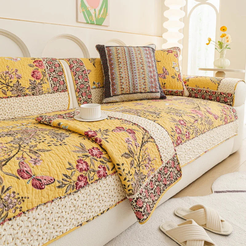 Un canapé lumineux et fleuri, orné de coussins colorés, crée une ambiance chaleureuse et apaisante dans cette pièce.