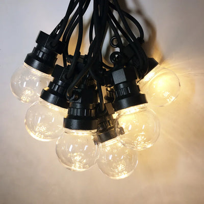 Guirlande lumineuse LED boule transparente suspendue dans un jardin