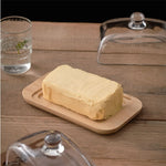 Beurrier transparent avec bouton noir sur fond de table en bois